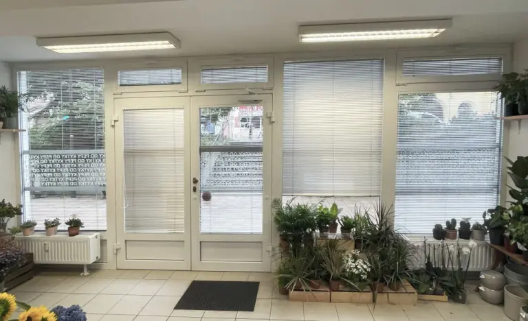 Bílé hliníkové horizontální žaluzie v prosklené okenní sestavě