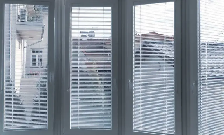 Bílé hliníkové žaluzie na plastových oknech